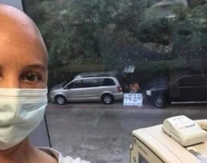 Com cartaz na janela, homem acompanha quimioterapia da esposa